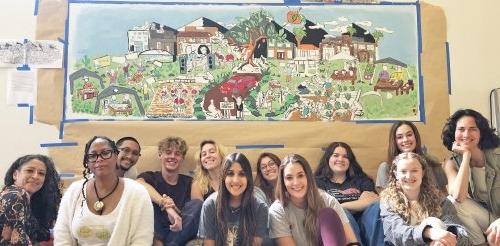 casa students and faculty pose in front of a mural project